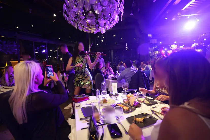 Mor ışıklı salonda bir performansı kaydeden misafirler