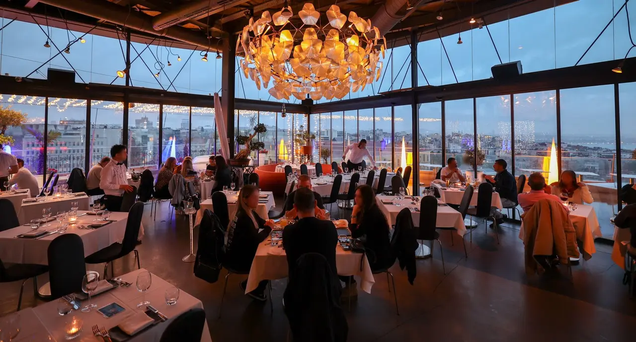 The glass-walled 360 Istanbul dining room at dusk with panoramic views over Beyoğlu
