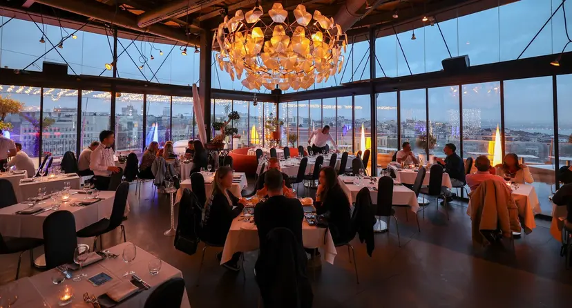 Gün batımında cam duvarlı 360 İstanbul restoranı ve Beyoğlu panoraması