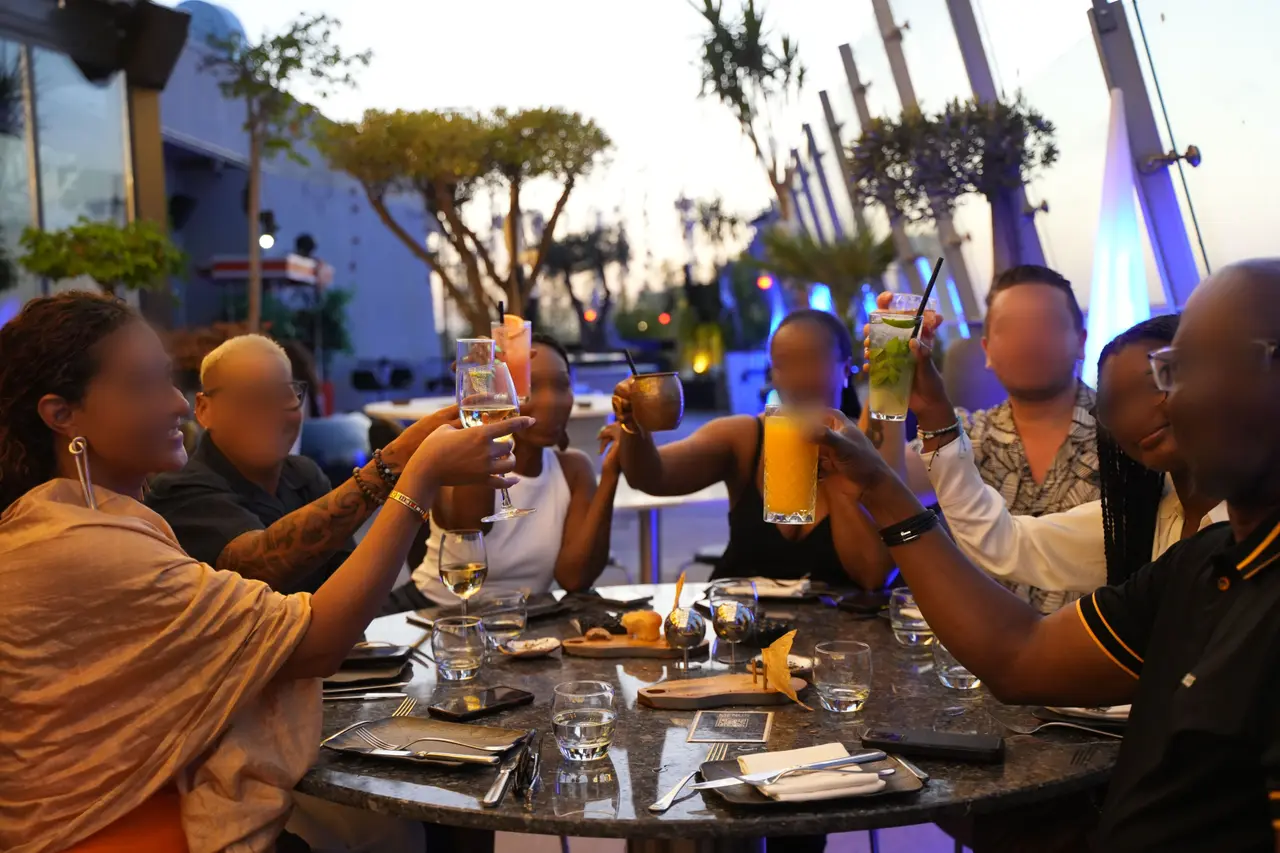 Gün batımında terasta kadeh kaldıran bir grup