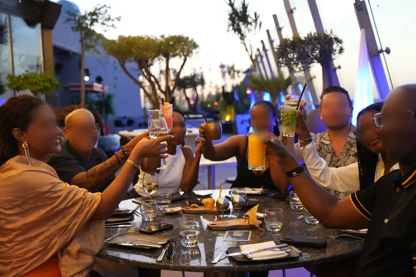 Gün batımında terasta kadeh kaldıran bir grup